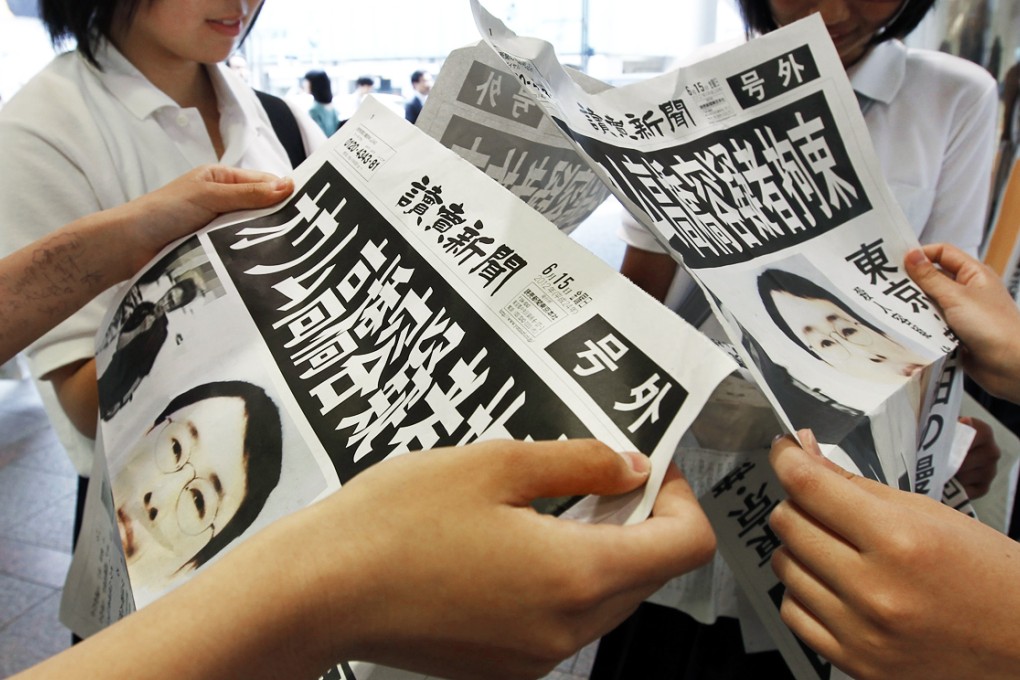 Pedestrians read newspapers extra editions reporting the arrest of Katsuya Takahashi, the last fugitive member of the former Doomsday cult AUM Shinrikyo. Photo: EPA