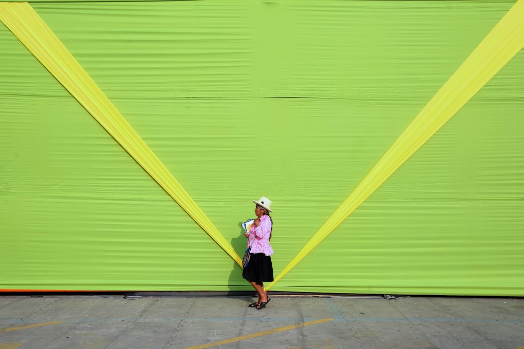 A woman wearing typical Andean attire walks past the installations being prepared for an event that's part of the UN climate conference in Lima. Photo: AFP
