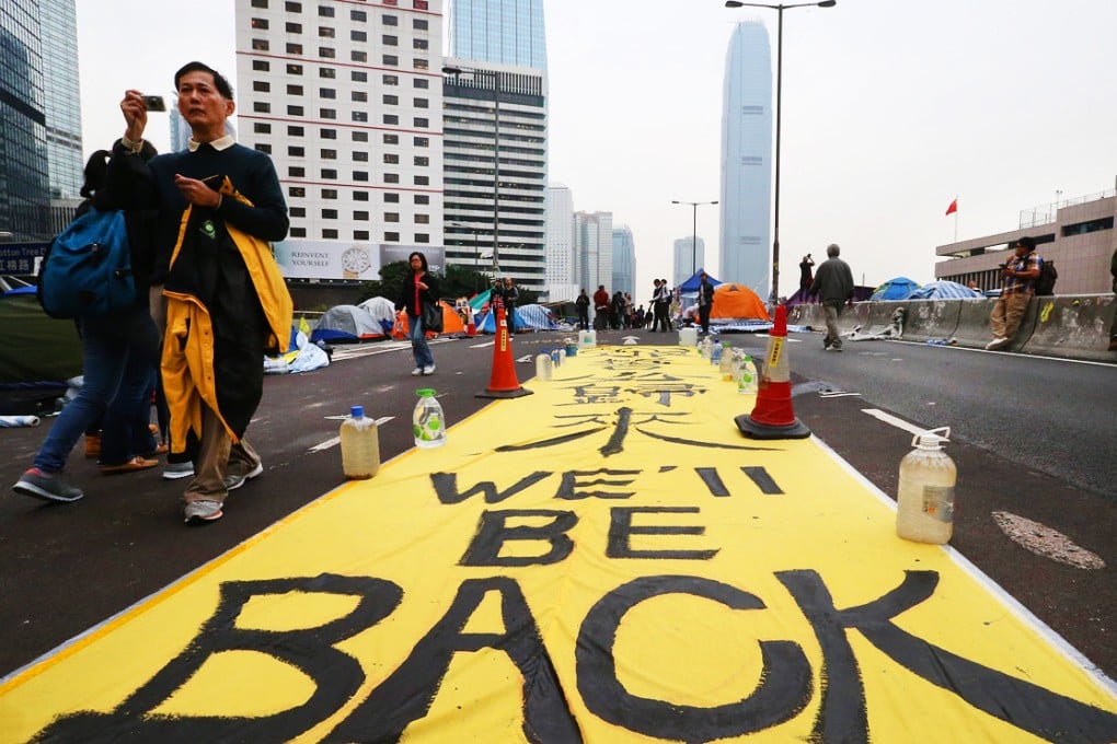 A huge banner reads "We'll be back" set up by pro-democracy protesters lies on an overpass at the financial Central district in Hong Kong. Photo: K.Y. Cheng