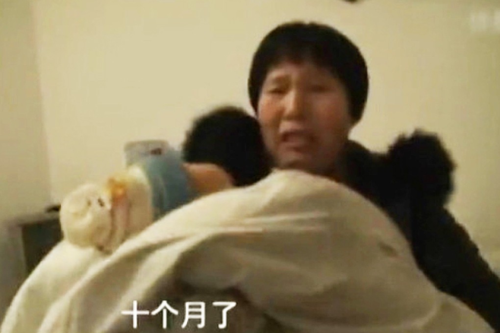 Zhang Yongling holds her 10-month old baby, her third child, after being freed from four days of illegal detention. Photo: SCMP