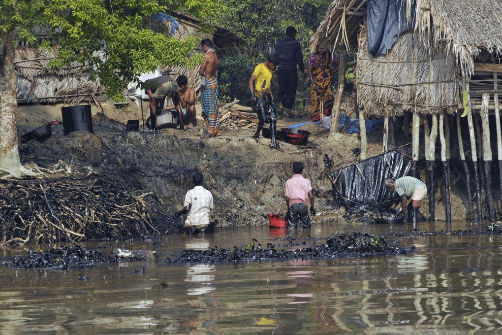 Bangladeshi villagers collect oil after tanker sank.Photo: AFP