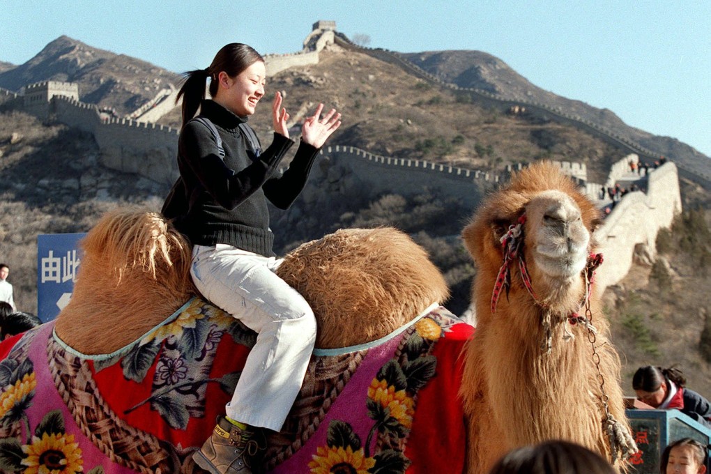 A Jiangsu couple makes 100,000 yuan a year travelling from province to province, charging tourists for taking photos with their camel. Photo: SCMP Pictures