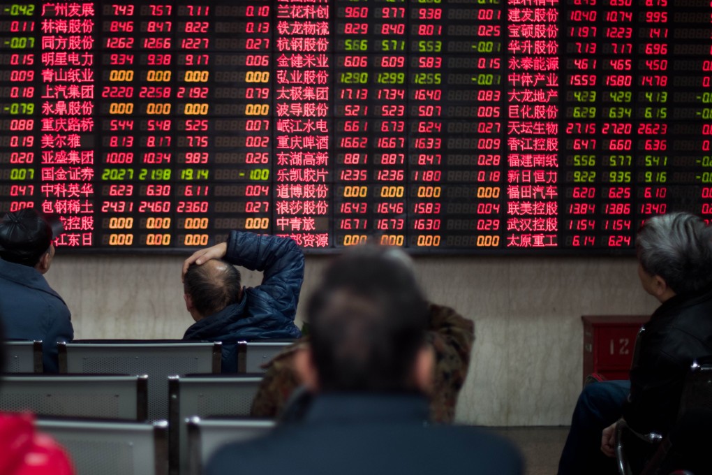 Investors look at stock information at a trading hall of a securities firm in Shanghai on December 10, 2014. Photo: AFP