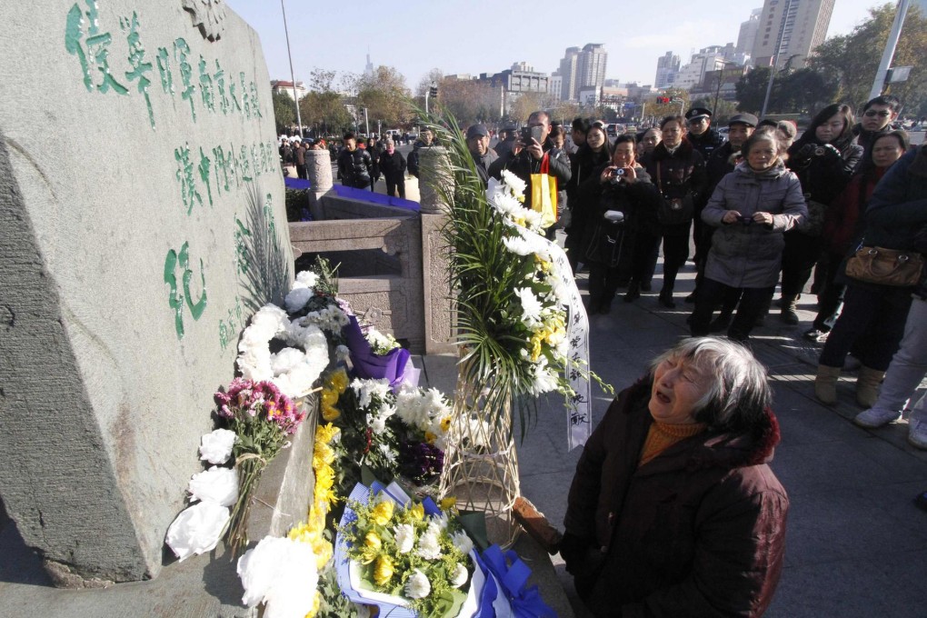 An 85-year-old woman survivor cries in front of a monument as she pays tribute during a memorial ceremony for the massacre in Nanjing . Dozens of events were held across the city. Photo: Reuters