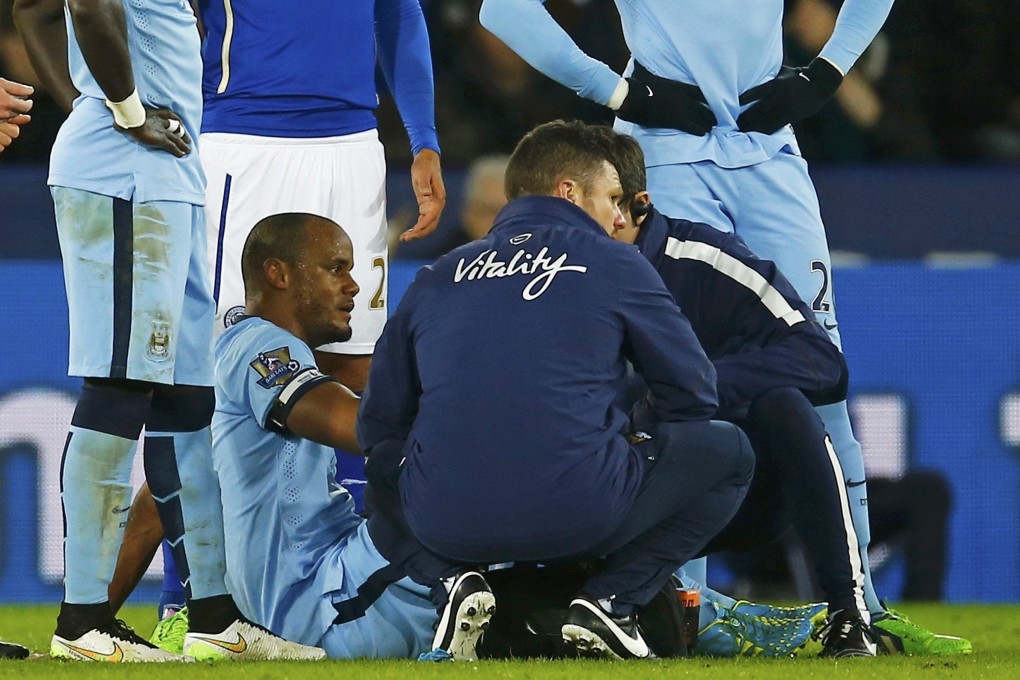 Vincent Kompany is assessed by medical staff after straining a hamstring during Manchester City's 1-0 win over Leicester City. Photo: Reuters