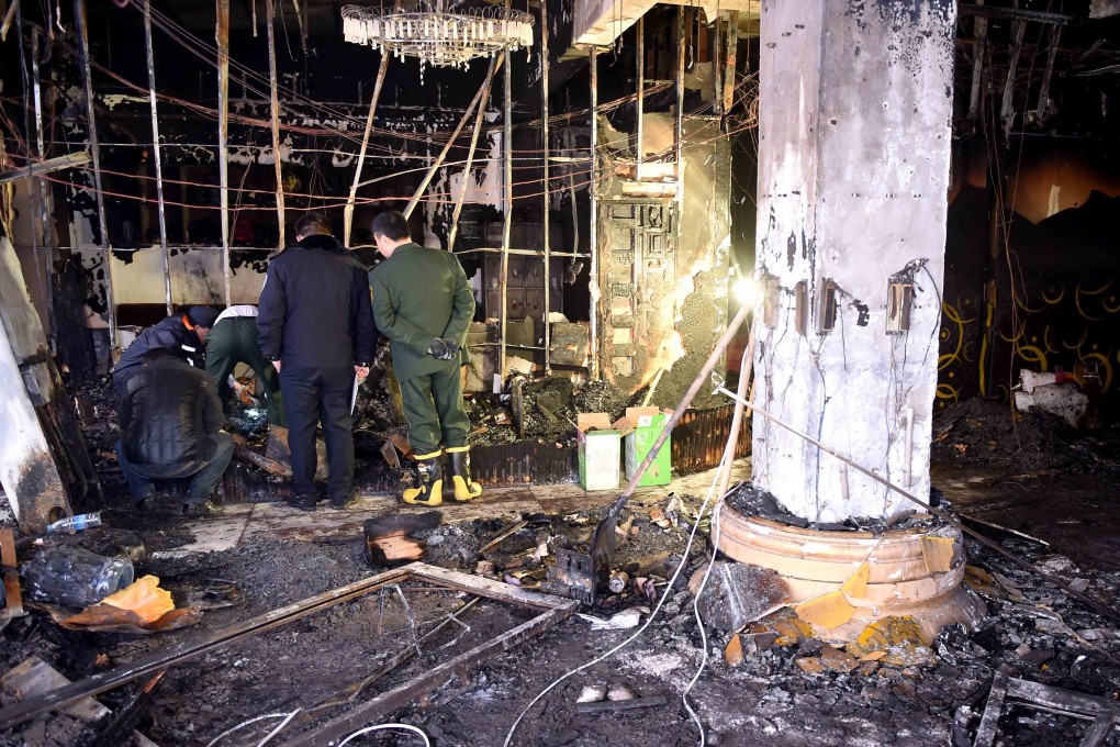 Police and firemen examine the scene of the fire that killed 11 people at a karaoke bar early this morning in Changyuan county, Henan province. Photo: Xinhua