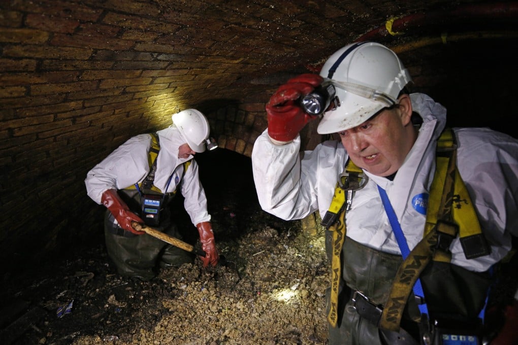 Sewer technician Tim Henderson (left), a "flusher" works alongside sewer supervisor Vince Minney (R) in the intersection of the Regent Street and Victoria sewer in London. Photo: AFP