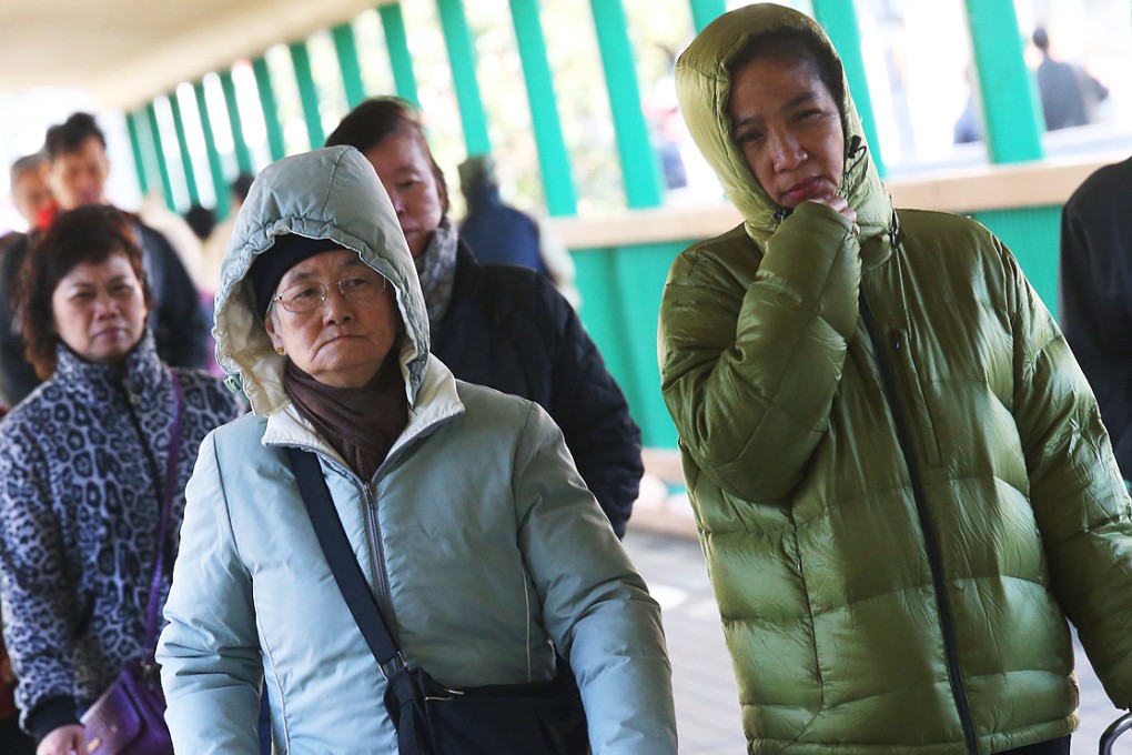 People wear thick clothes under the cold weather in Hung Hom. Photo: K.Y. Cheng