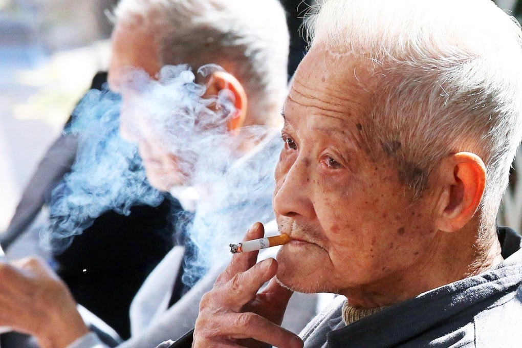 An elderly man puffs on a cigarette, a habit said to increase serious risks to health. Photo: K.Y. Cheng