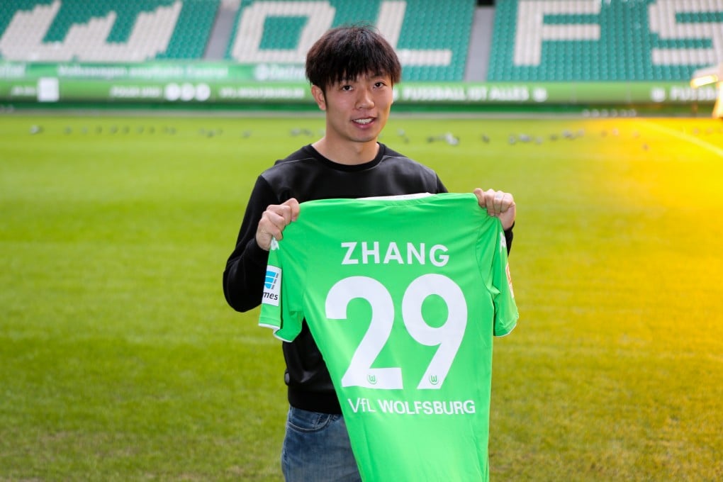 Zhang Xizhe displays his Wolfsburg jersey. Photo: Xinhua