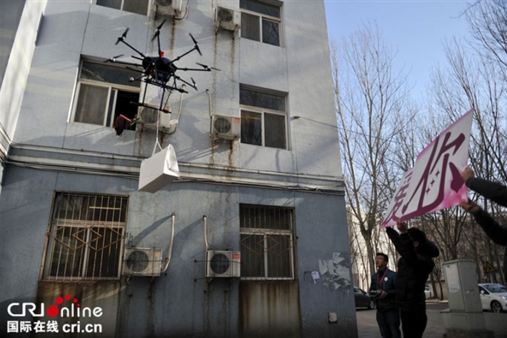 The would-be Chinese 'Romeo' flies a drone carrying a luxury bag up to the window of his 'Juliet', as his friends hold up a sign declaring his love. Photo: cri.cn