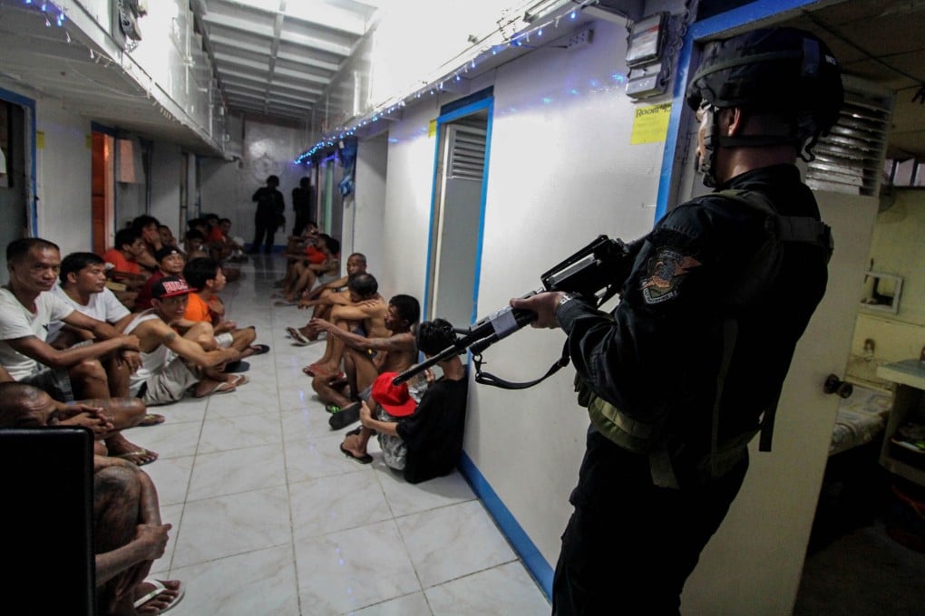 National Bureau of Investigation (NBI) operatives round up inmates inside New Bilibid Prison in Muntinlupa, south of Manila. Photo: AFP