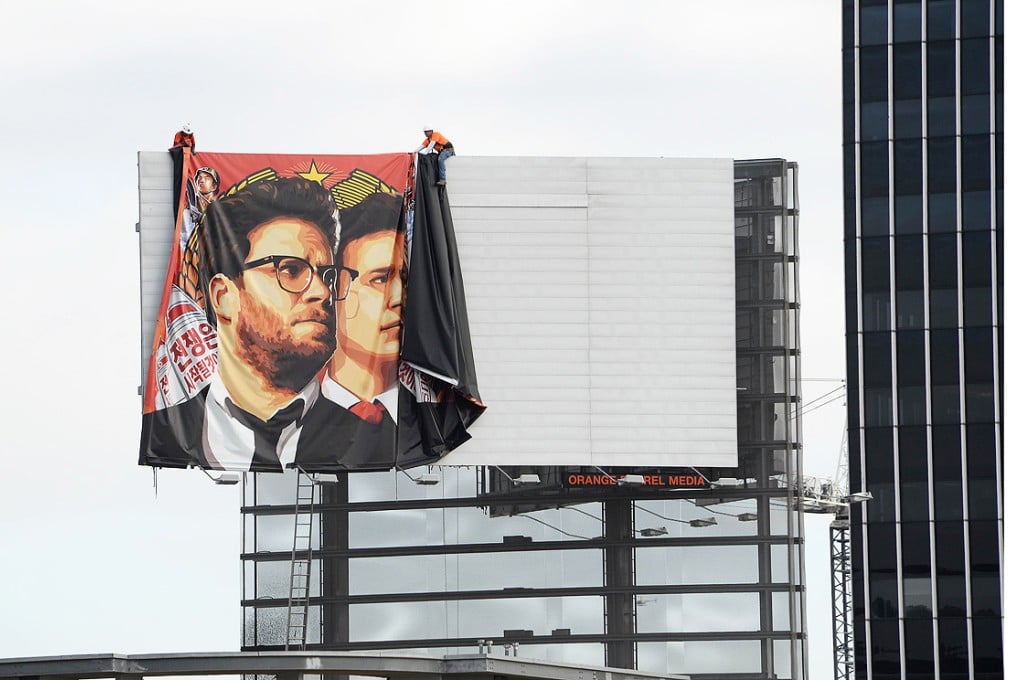 Workers remove a poster for "The Interview" from a billboard in Hollywood, California on Thursday after Sony film studio announced it had no choice but to cancel the movie's Christmas release. Photo: AFP