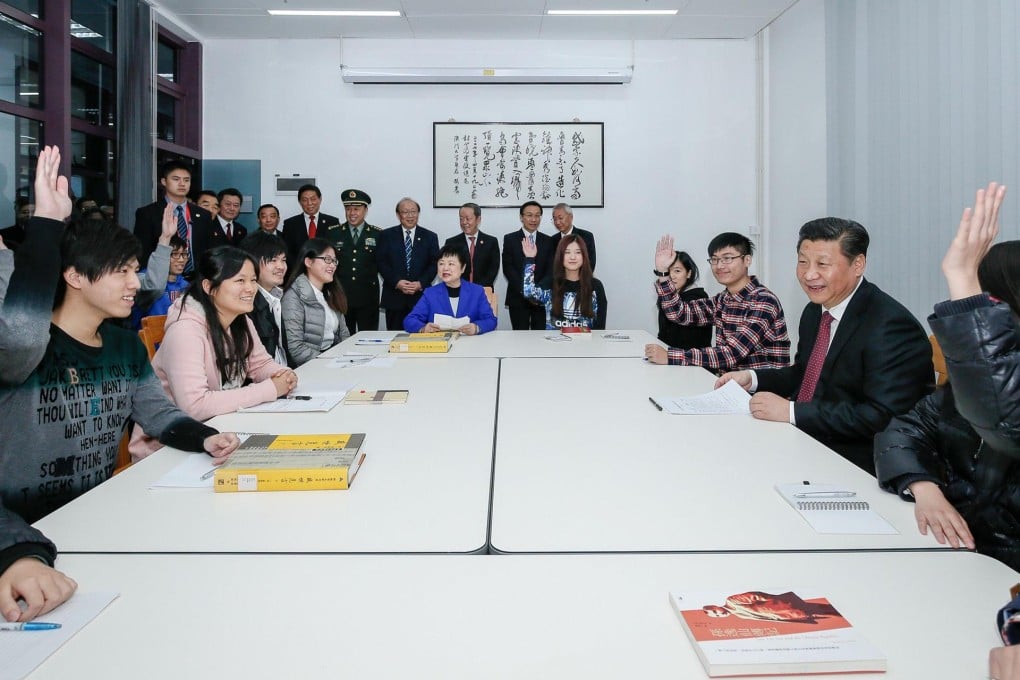 President Xi Jinping sits down with students at Macau University's new Hengqin Island campus as officials look on. Photo: AFP