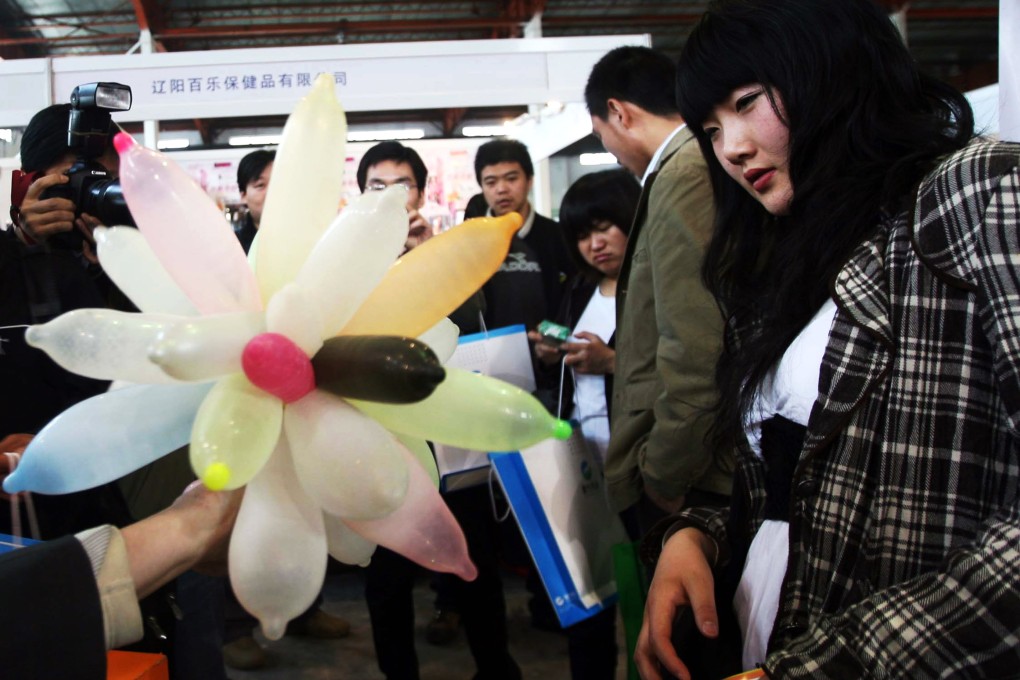 People check out condoms on display at a fair. Some sex shops in Beijing are selling cheap counterfeit condoms that cost a fraction the price of real ones. Photo: AFP