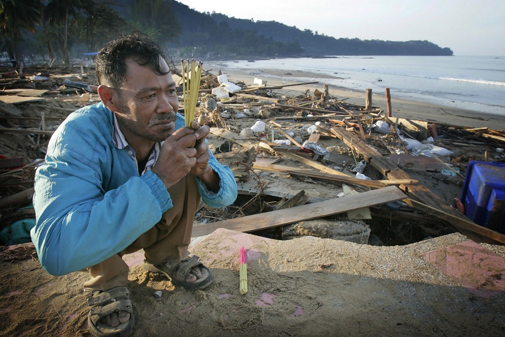 In this photo taken near Khao Lak, Thailand, on December 29, 2004, a man offered prayers for his sister who was swept out to sea. Photo: AP