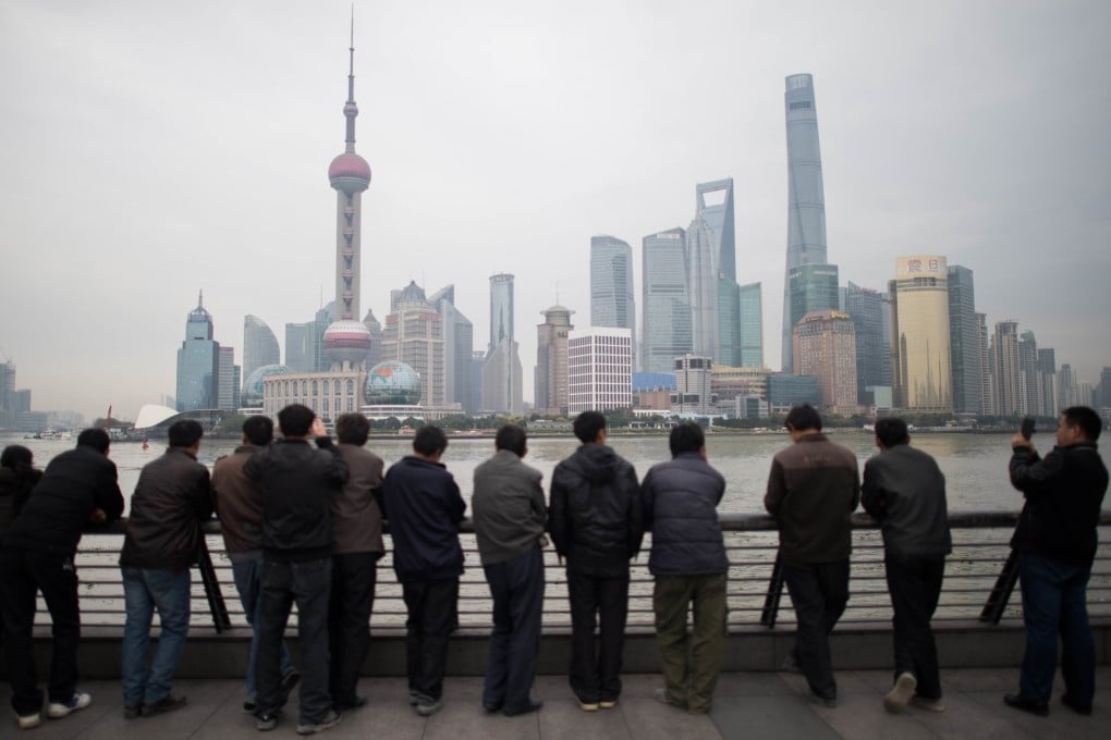Chinese tourists stand along the promenade on the Bund overlooking the Huangpu River against the skyline of the Pudong district in Shanghai on December 10, 2014.  Photo: AFP