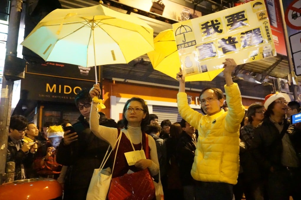 Protesters hold up a yellow umbrella and banners demanding true universal suffrage in Mong Kok. Photo: Chris Lau