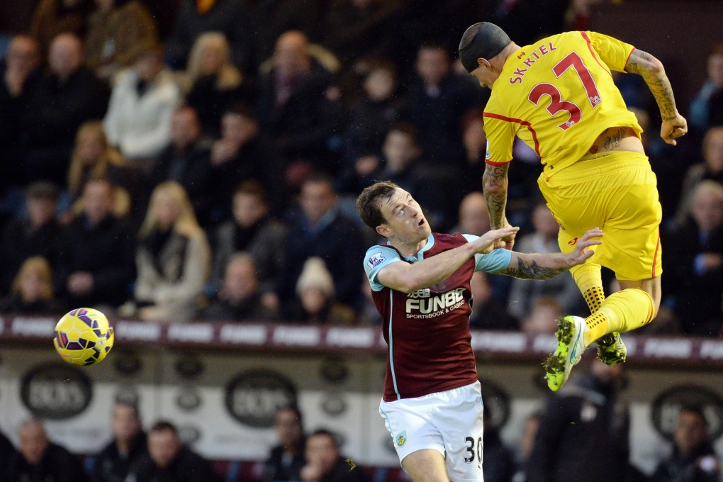 Liverpool defender Martin Skrtel heads the ball under pressure from Burnley striker Ashley Barnes. Photo: AFP