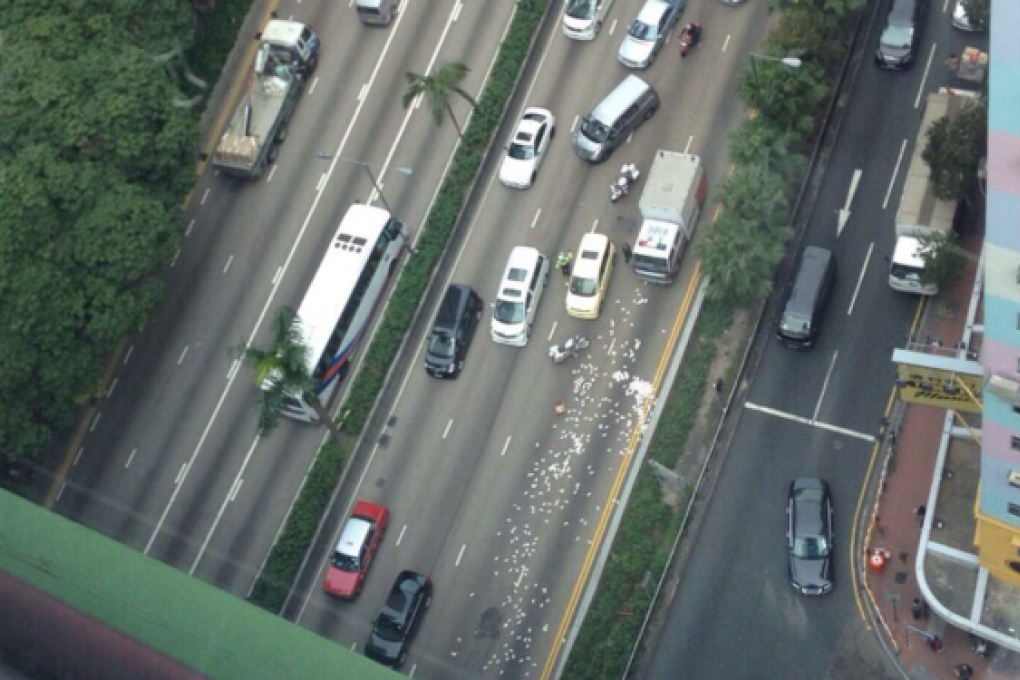 Cash is strewn over Gloucester Road in Wan Chai. Photo: SCMP