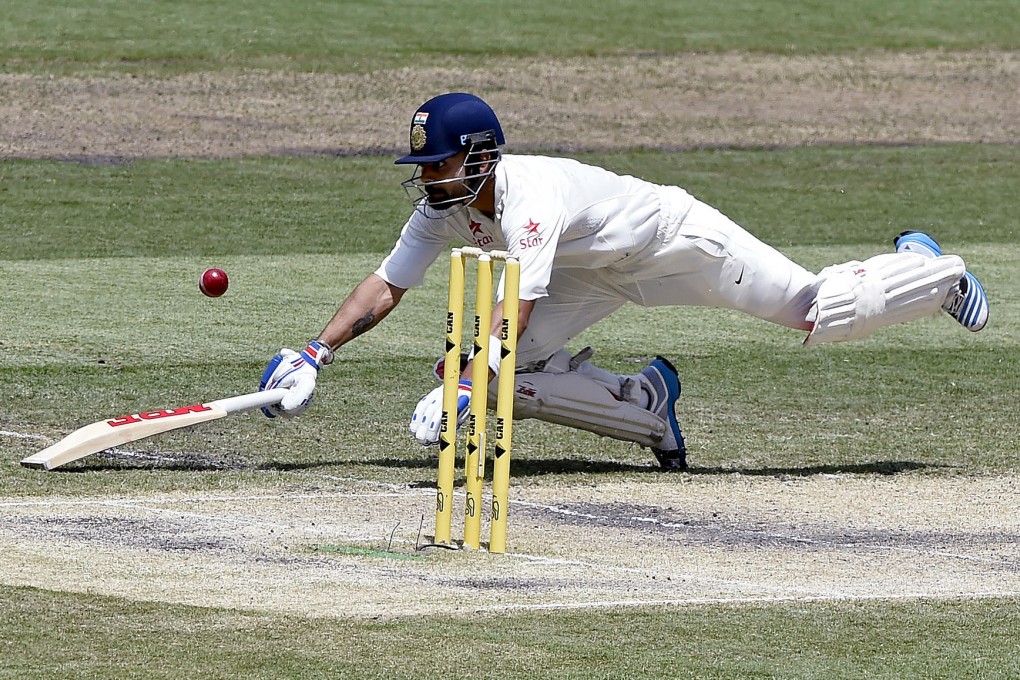 Virat Kohli dives back to his crease to avoid a run out on his way to 169 on the third day of the third test against Australia. Photo: AP