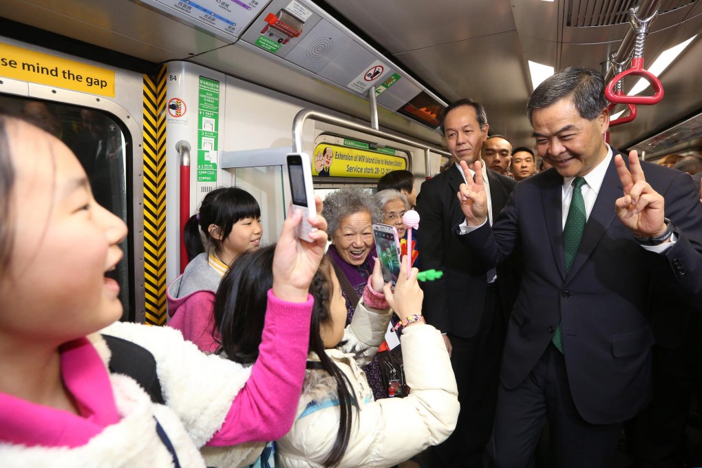 Chief Executive Leung Chun-ying (right) takes a ride on the MTR's new Island Line extension, which opens today, a victory in a hard year for the railway. Photo: Sam Tsang