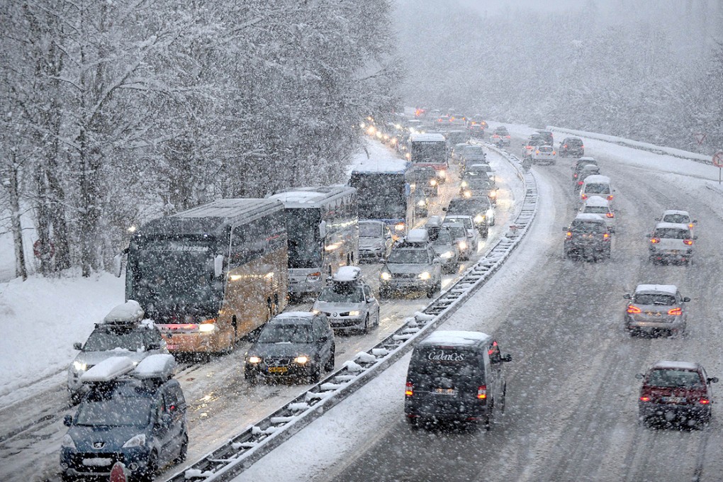 Snow falls as vehicles move bumper-to-bumper on Saturday as they make their way into the Tarentaise Valley in the heart of the French Alps. Photo: AFP