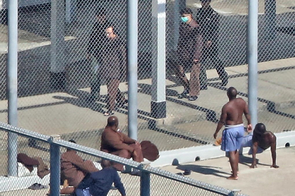 All eyes turn to gaze at disgraced tycoon Thomas Kwok as he walks in front of a yard at Stanley Prison yesterday. Photo: SCMP Pictures