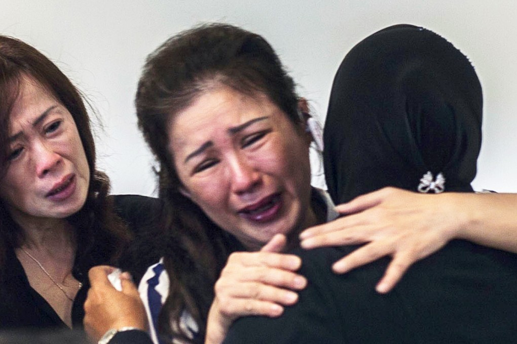 Bracing for the worst, a relative of a QZ 8501 passenger weeps at the Surabaya airport as the second day of search operations for the missing jet yields little answers. Photo: AFP