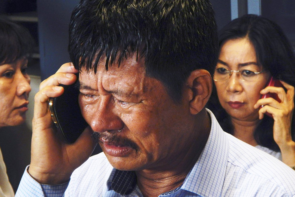 Family members of passengers on board AirAsia flight QZ 8501 talk on their phones at an airport crisis centre in Surabaya. Photo: Reuters