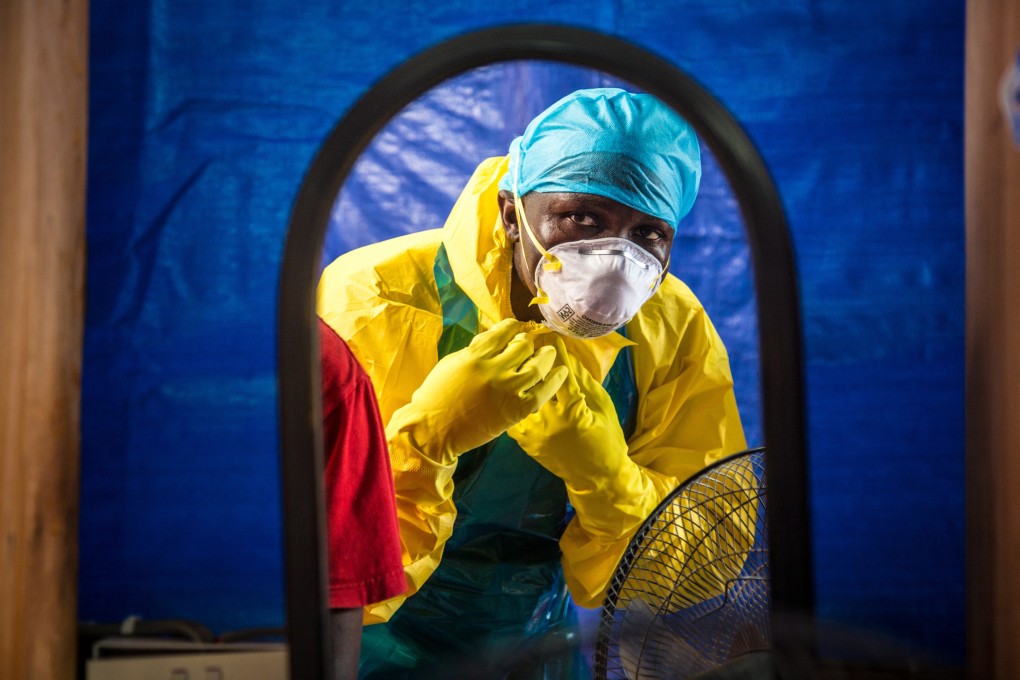 A healthcare worker dons protective gear before entering an Ebola treatment center in the west of Freetown, Sierra Leone. Photo: AP