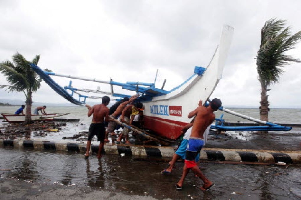 Fishermen move a boat in Legazpi as Typhoon Hagupit approaches. Photo: EPA