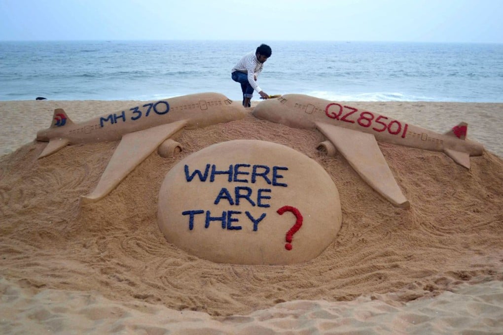 Indian sand artist Sudarsan Pattnaik with his sand sculpture portraying two missing aircraft, Air Asia QZ8501 and Malayasia Airlines MH370. Photo: AFP