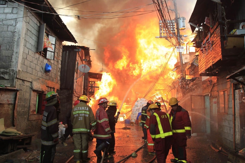 Firefighters douse water as they try to put out a raging fire that raced through nearly a kilometer long row of shanties in Quezon city, metro Manila. Photo: Reuters