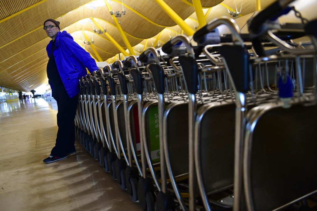 Homeless Bulgarian Valentin Giorgiev in front of luggage trolleys at Barajas Adolfo Suarez Airport's terminal 4 in Madrid which is the closest thing he has to a home. Photo: AFP