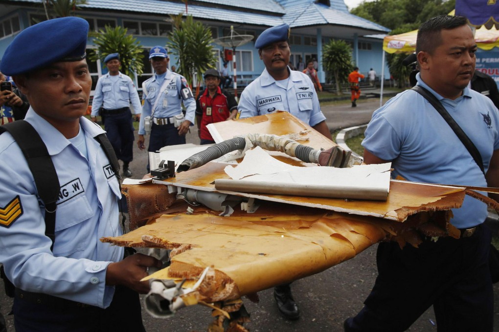 Officials carry what is believed to be debris from the crashed AirAsia plane after it arrives in Pangkalan Bun yesterday. Photo: Reuters