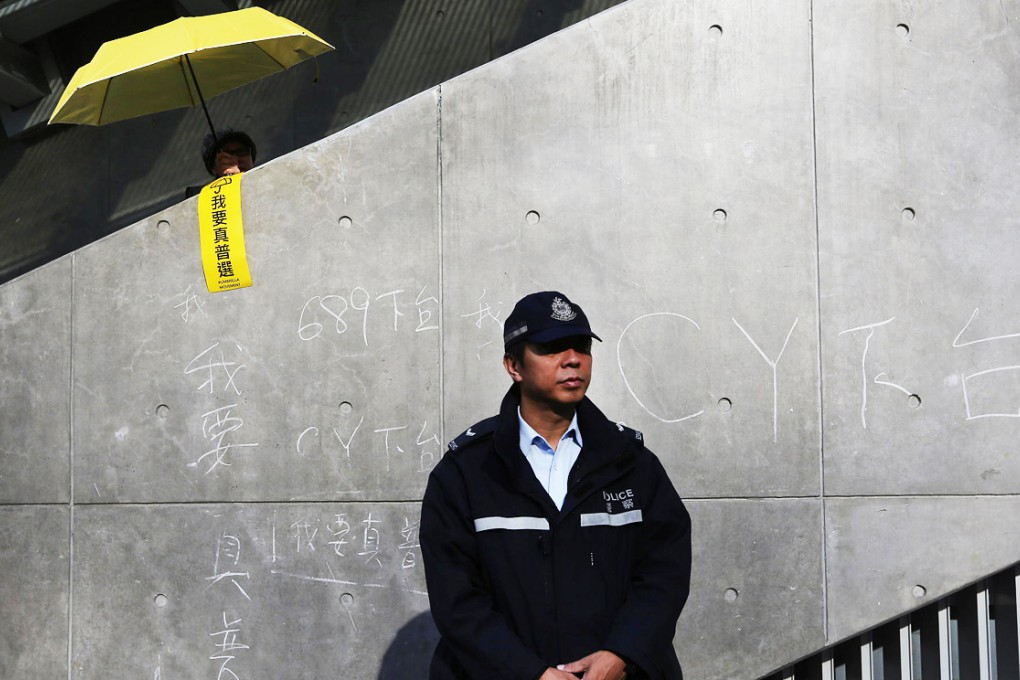 A police officer prevents further chalk graffiti.Photo: Sam Tsang