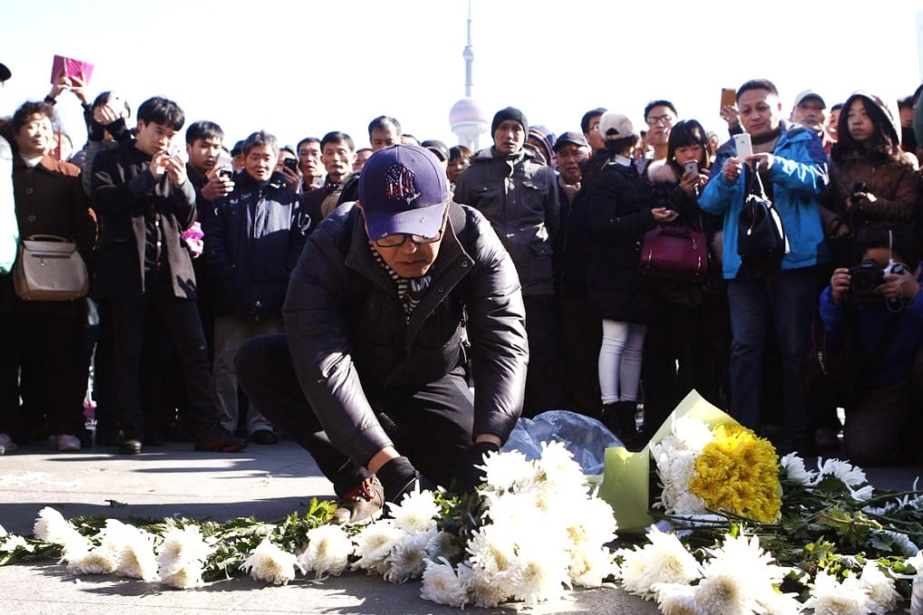 People place flowers yesterday at the site of a deadly stampede on Shanghai's riverfront. At least 36 people were killed and dozens more were injured in the New Year's Eve tragedy. Photo: EPA