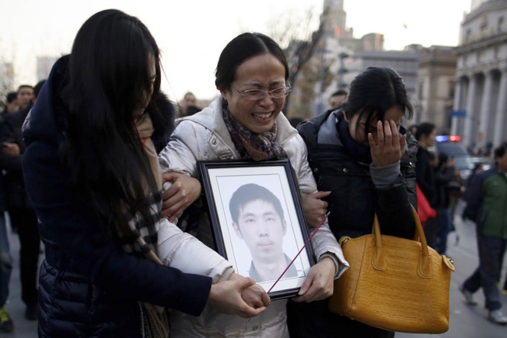 A woman holds a photo of her son who died in the New Year's Eve stampede. Photo: Reuters