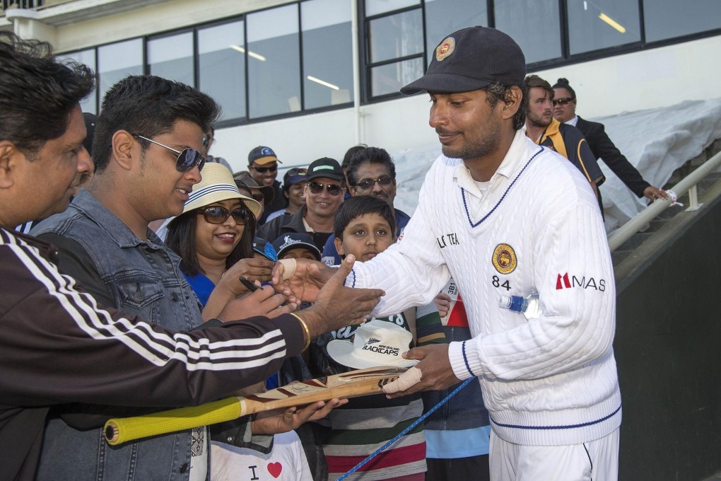 Sri Lanka's Kumar Sangakkara signs autographs after his double hundred in the second test against New Zealand. Photos: AFP