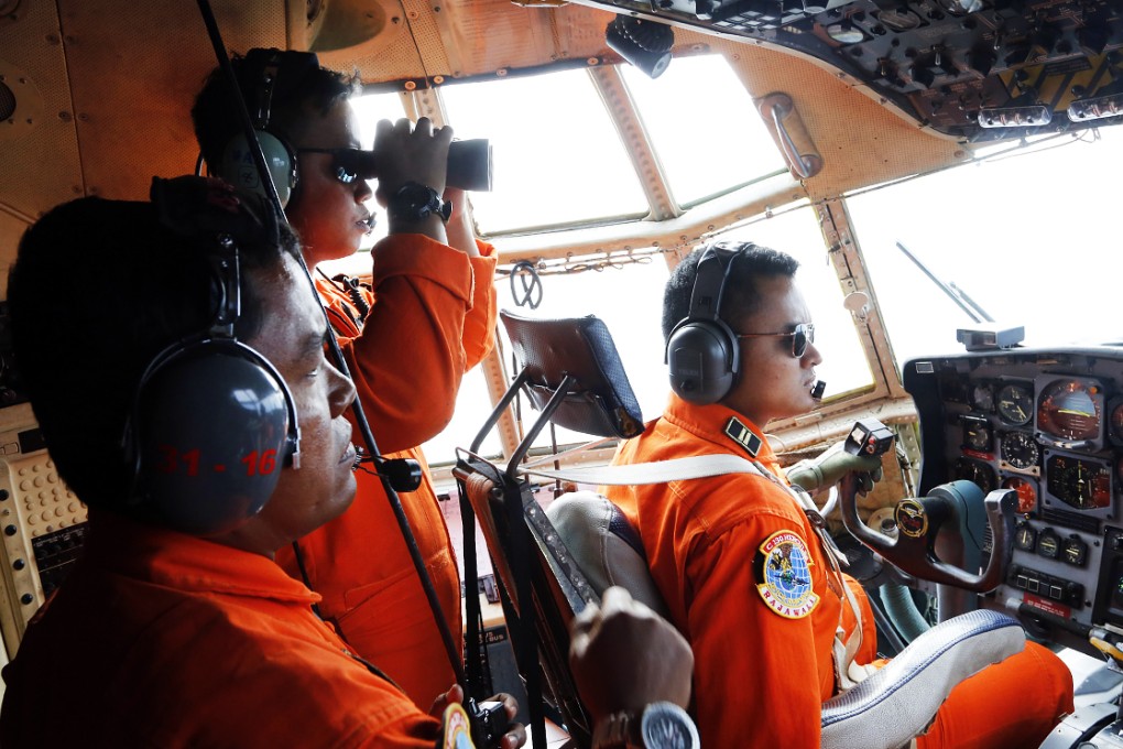 Crew of Indonesian Air Force C-130 airplane of the 31st Air Squadron scan the horizon during a search operation for the missing AirAsia flight 8501 over the waters of Karimata Strait in Indonesia. Photo: AP