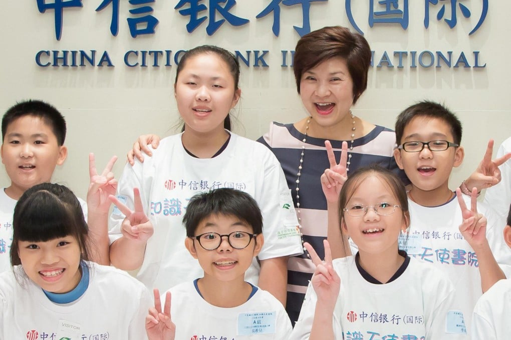 A group of happy youngsters attending a bank charity event give the victory sign with executive director Helen Kan. Photo: China CITIC Bank International