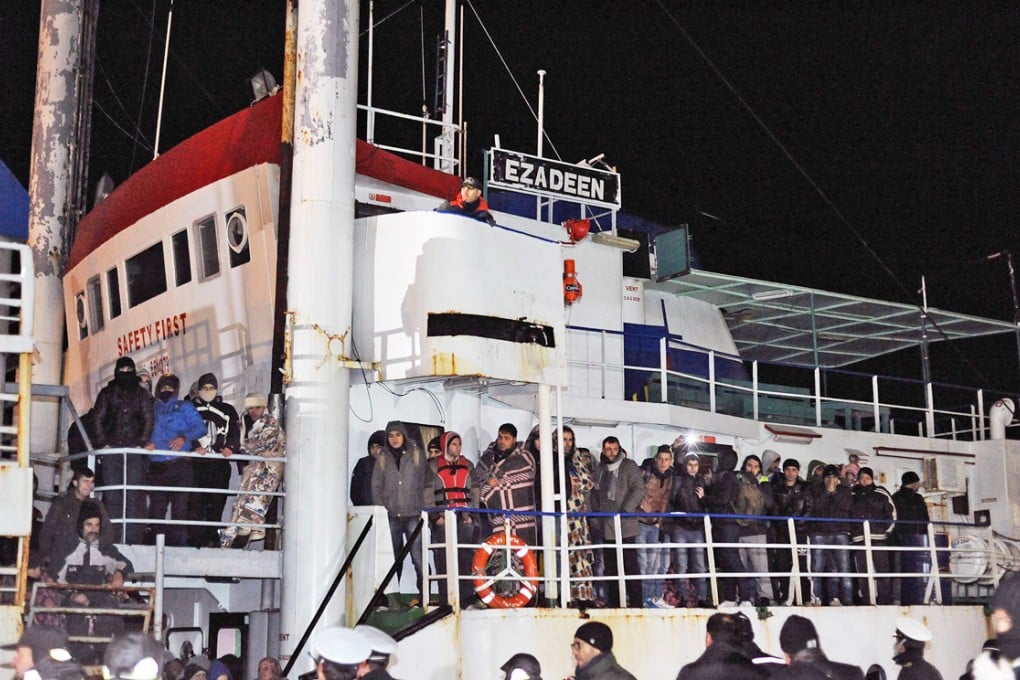 Italian police looks at migrants aboard the Ezadeen ship at Corigliano harbour after the boat was intercepted by the Italian coastguard. Photo: EPA