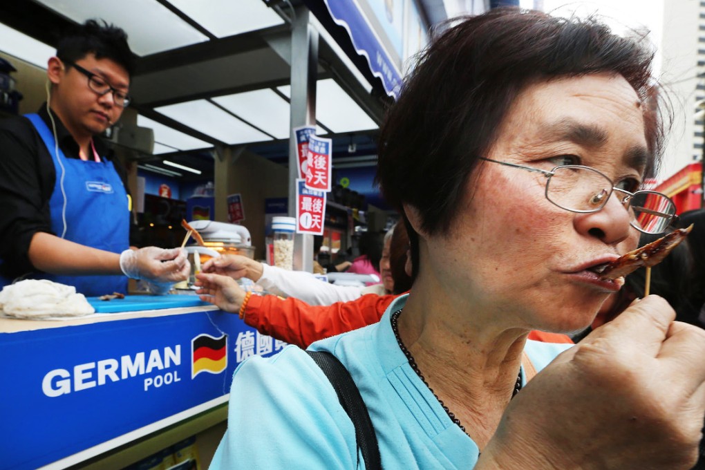 A shopper munches on a snack as one of the city's biggest retail fairs comes to an end in Victoria Park yesterday. Photo: Sam Tsang