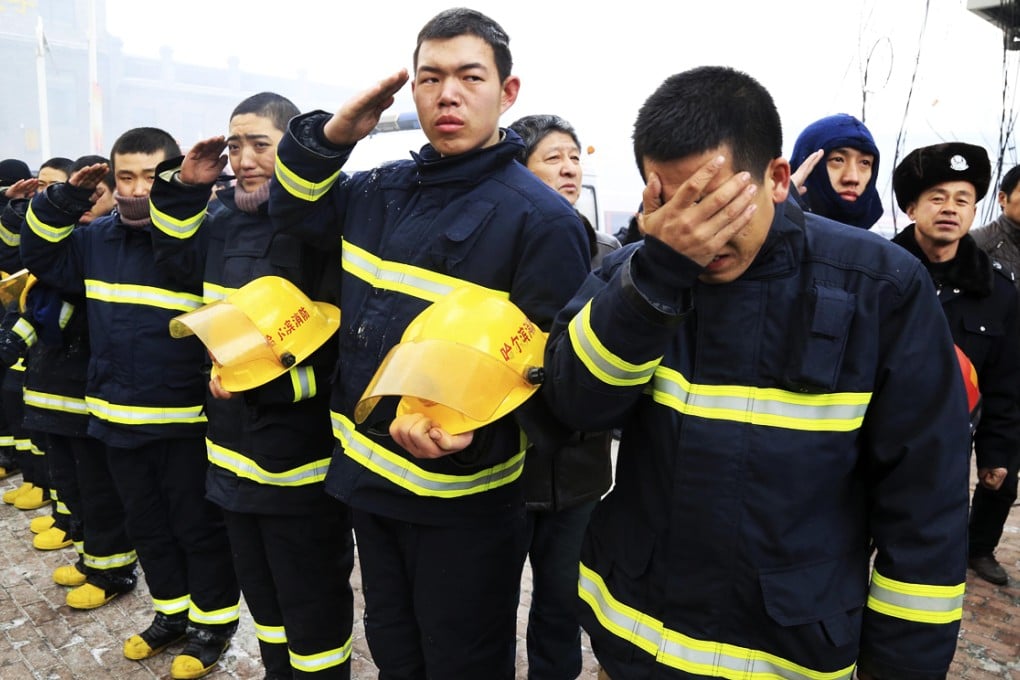 Firefighters salute and cry as they mourn for fellow firefighters, who were killed after a building collapsed during a fire, in Harbin, Heilongjiang. Photo: Reuters