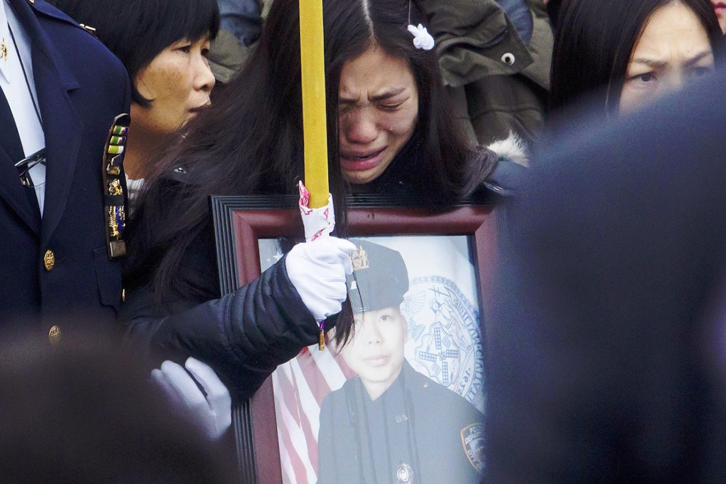 Widow Pei Xia Chen cries as she clutches a photo of her husband, NYPD officer Wenjian Liu. Photo: AFP
