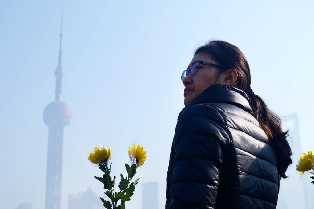 A woman holds a flower bouquet as she prepares to pray for victims of the New Year's stampede in Shanghai. Photo: AFP