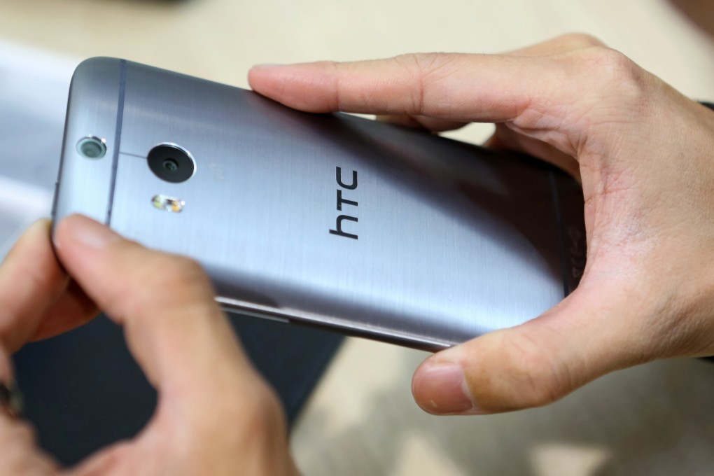 A customer looks at an HTC smartphone as the struggling Taiwan firm reported its first quarterly increase in revenues after years of falling sales. Photo: Bloomberg