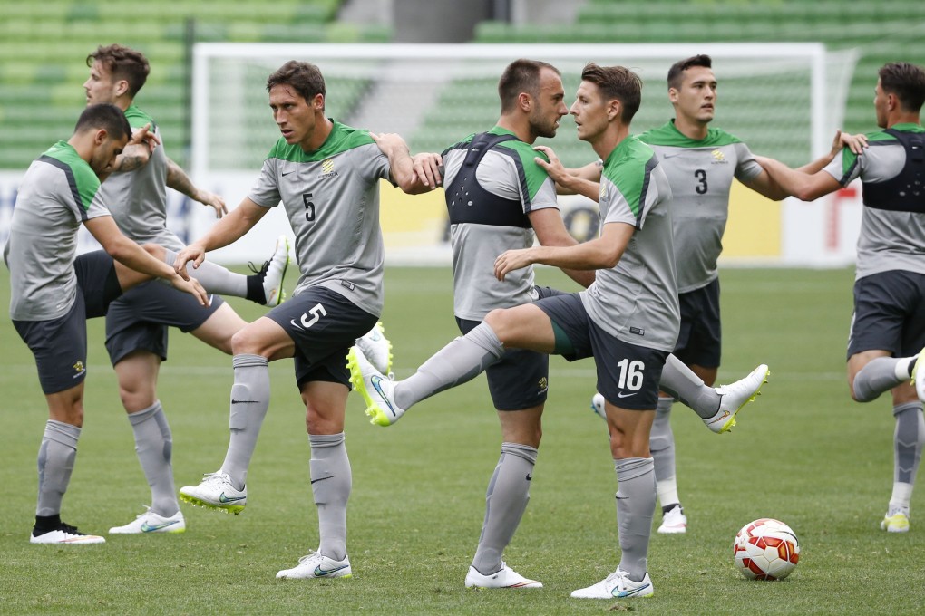 Australian players limber up at a training session at Melbourne Rectangular Stadium in preparation for their opening game against Kuwait in the Asian Cup. Photo: Kyodo