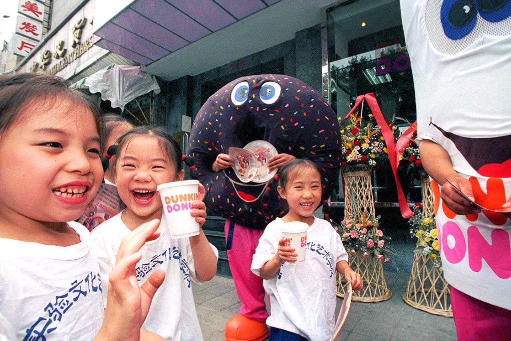 Children frolic at a Dunkin' Donuts store in Beijing. The popular US chain has partnered with Philippine burger giant Jollibee to open 1,400 locations in mainland China. Photo: Reuters